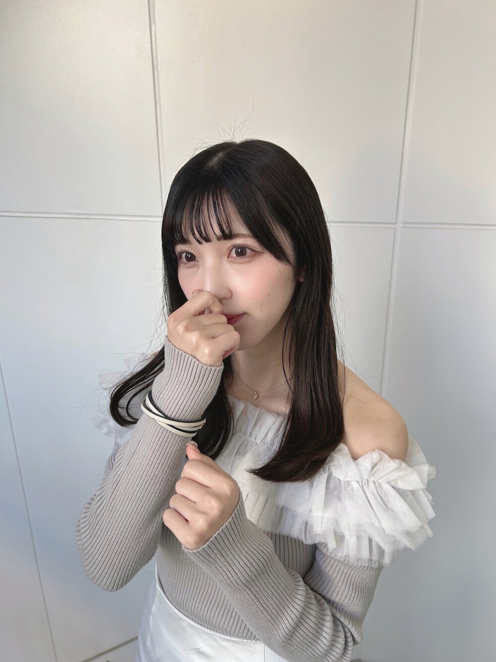 ホワイト系のスカート、ベージュ系のニット/セーターを着用したレディースの春コーディネートの4枚目の写真