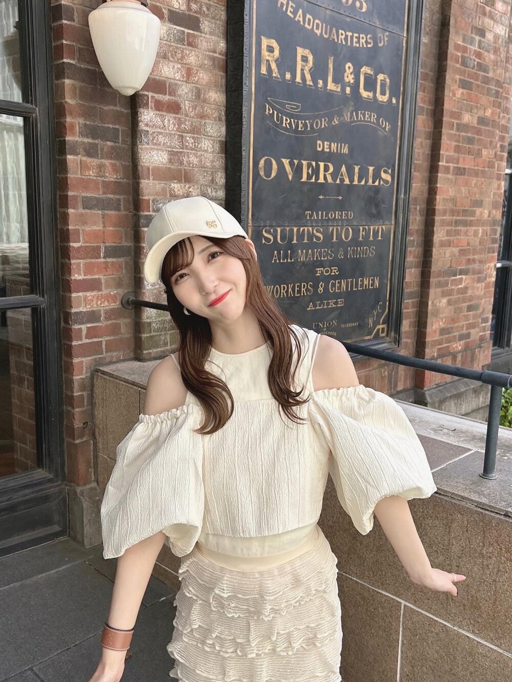 ホワイト系のスニーカー、ホワイト系のトップス、ベージュ系のタンクトップを着用したレディースの夏コーディネートの4枚目の写真