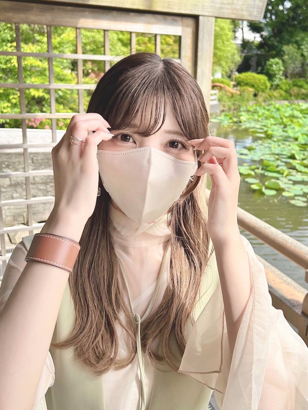 グリーン系のジャンパースカート、ベージュ系のシャツ/ブラウス、ベージュ系のブーツを着用したレディースの春コーディネートの2枚目の写真