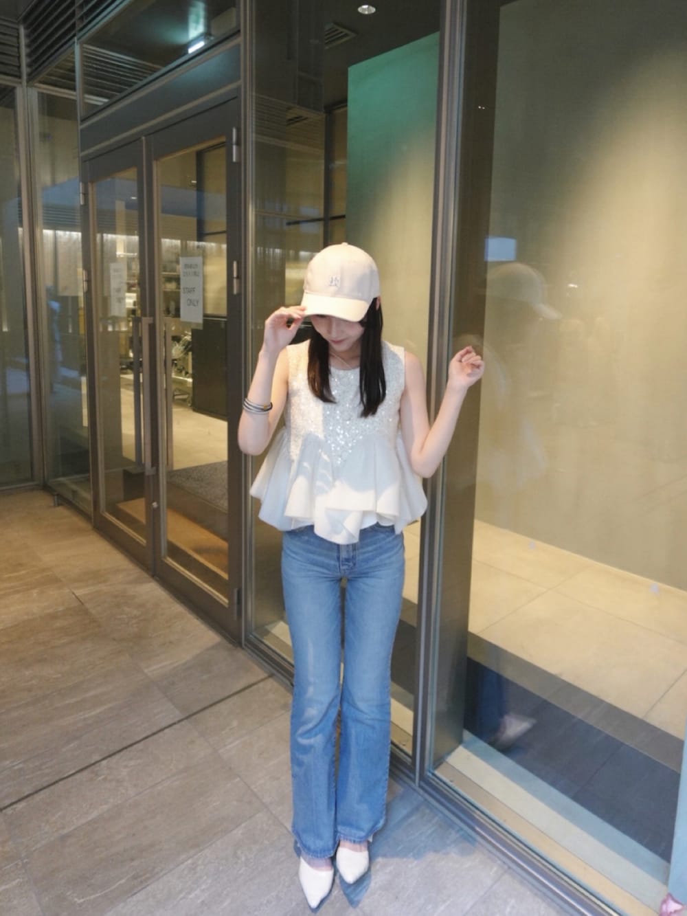 ホワイト系のパンプス、ホワイト系のシャツ/ブラウス、ブルー系のデニムパンツを着用したレディースの夏コーディネートの3枚目の写真