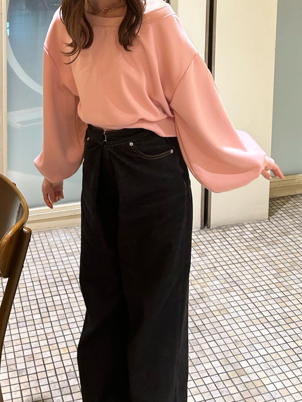 ピンク系のスウェット、ブラック系のデニムパンツを着用したレディースの秋コーディネートの2枚目の写真