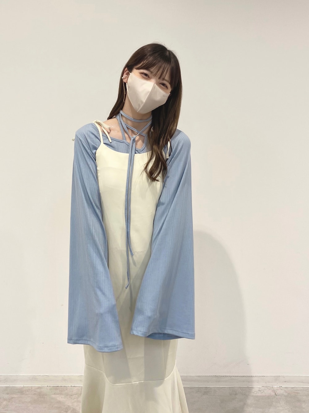 ホワイト系のワンピース、ブルー系のトップス、ホワイト系のバレエシューズを着用したレディースの春コーディネートの2枚目の写真