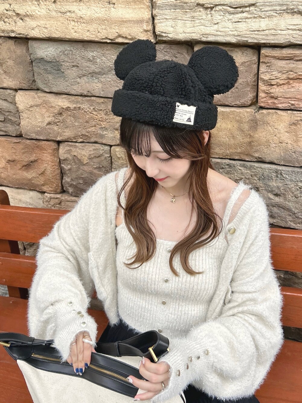 ホワイト系のアンサンブル、ブラック系のスカートを着用したレディースの秋コーディネートの3枚目の写真