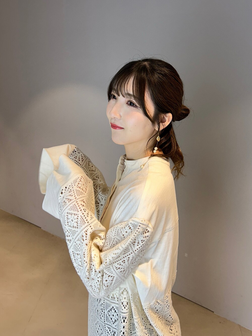 ホワイト系のシャツワンピース、ブルー系のデニムパンツを着用したレディースの夏コーディネートの2枚目の写真