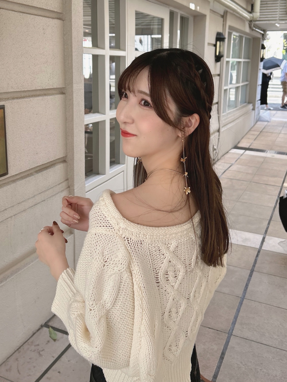 ホワイト系のニット/セーター、ブラック系のデニムパンツ、ホワイト系のブーツを着用したレディースの夏コーディネートの4枚目の写真