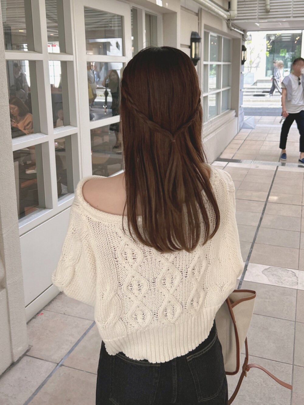 ホワイト系のニット/セーター、ブラック系のデニムパンツ、ホワイト系のブーツを着用したレディースの夏コーディネートの5枚目の写真