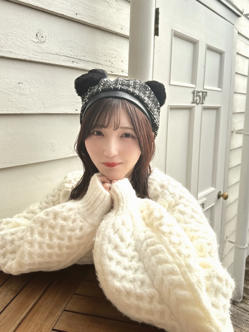 ブラウン系のブーツ、ホワイト系のニット/セーター、ホワイト系のキャミソールを着用したレディースの冬コーディネートの3枚目の写真