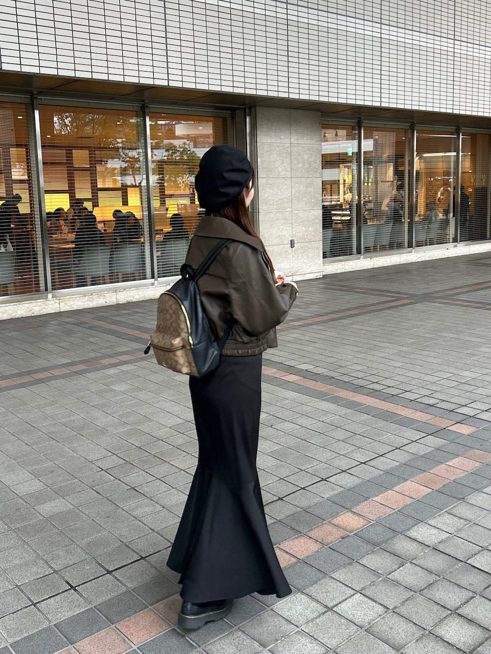 ホワイト系のトップス、ブラック系のスカート、ブラック系のブーツを着用したレディースの秋コーディネートの2枚目の写真