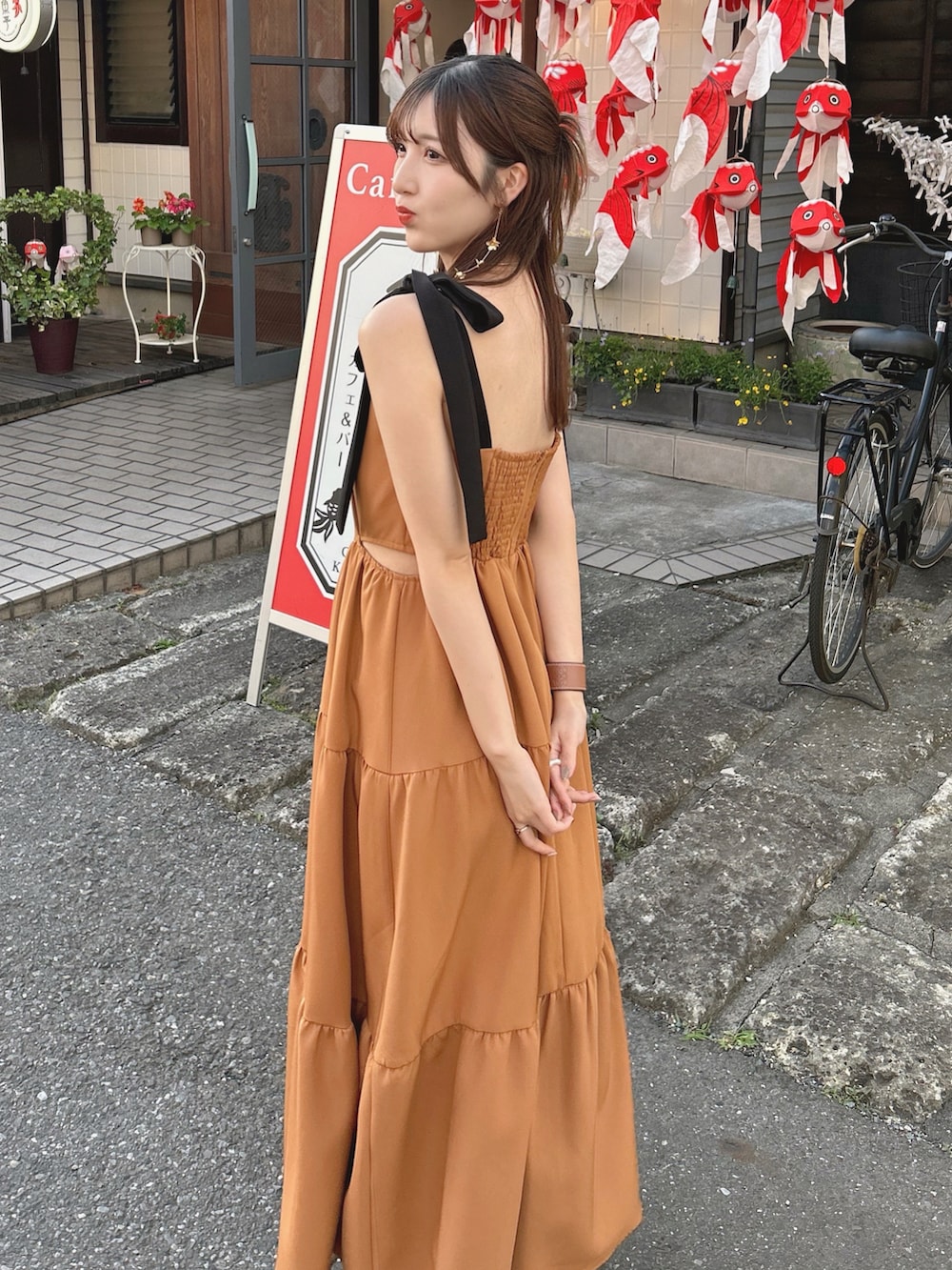 オレンジ系のワンピース/ドレスを着用したレディースの夏コーディネートの2枚目の写真