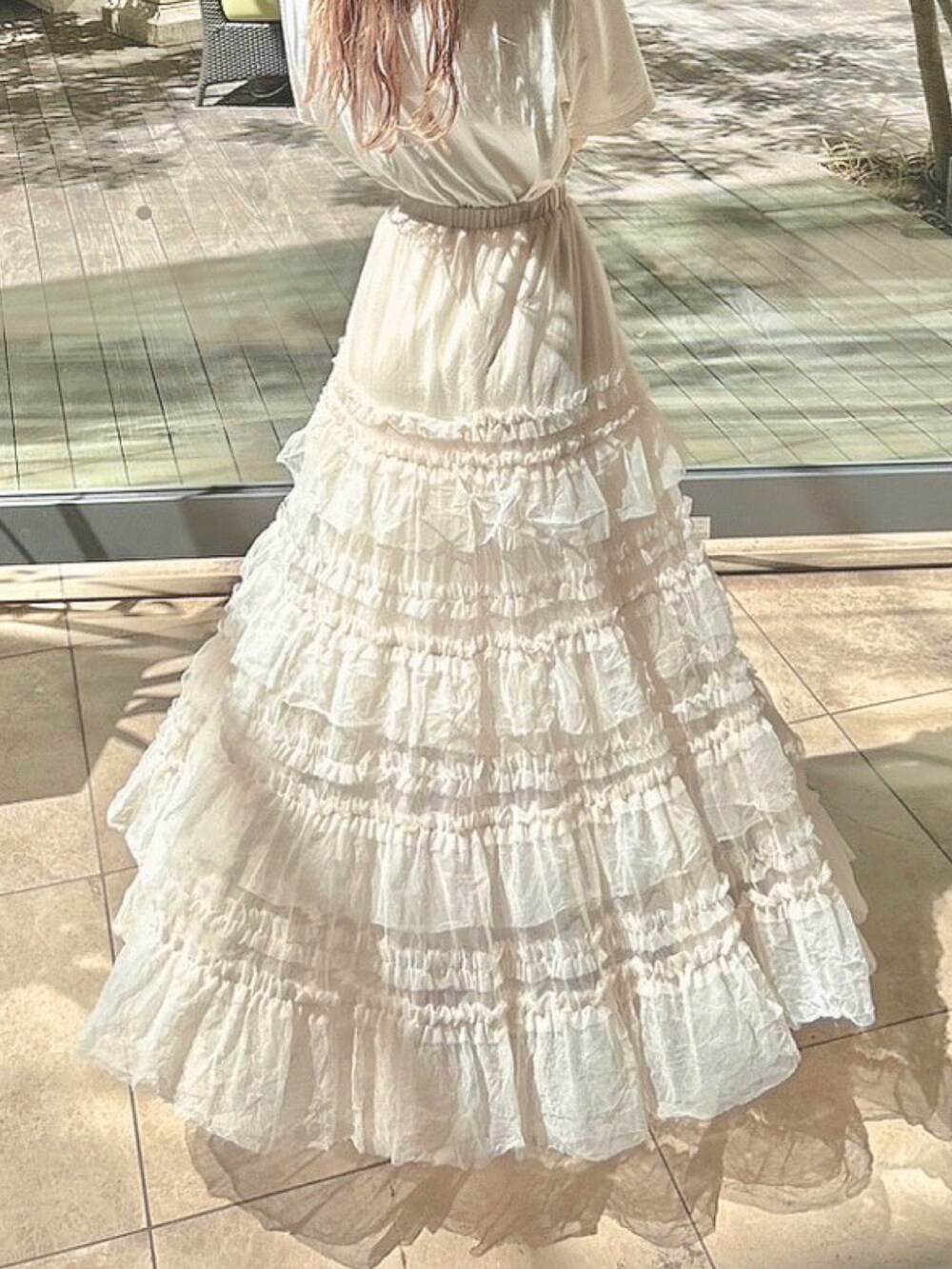 ベージュ系のスカート、ホワイト系のTシャツ/カットソー、ホワイト系のサンダルを着用したレディースの夏コーディネートの2枚目の写真