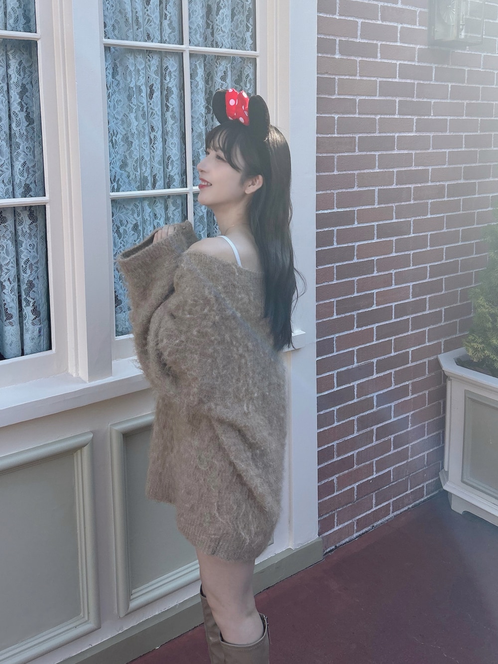 ブラウン系のニット/セーター、ベージュ系のブーツを着用したレディースの春コーディネートの3枚目の写真