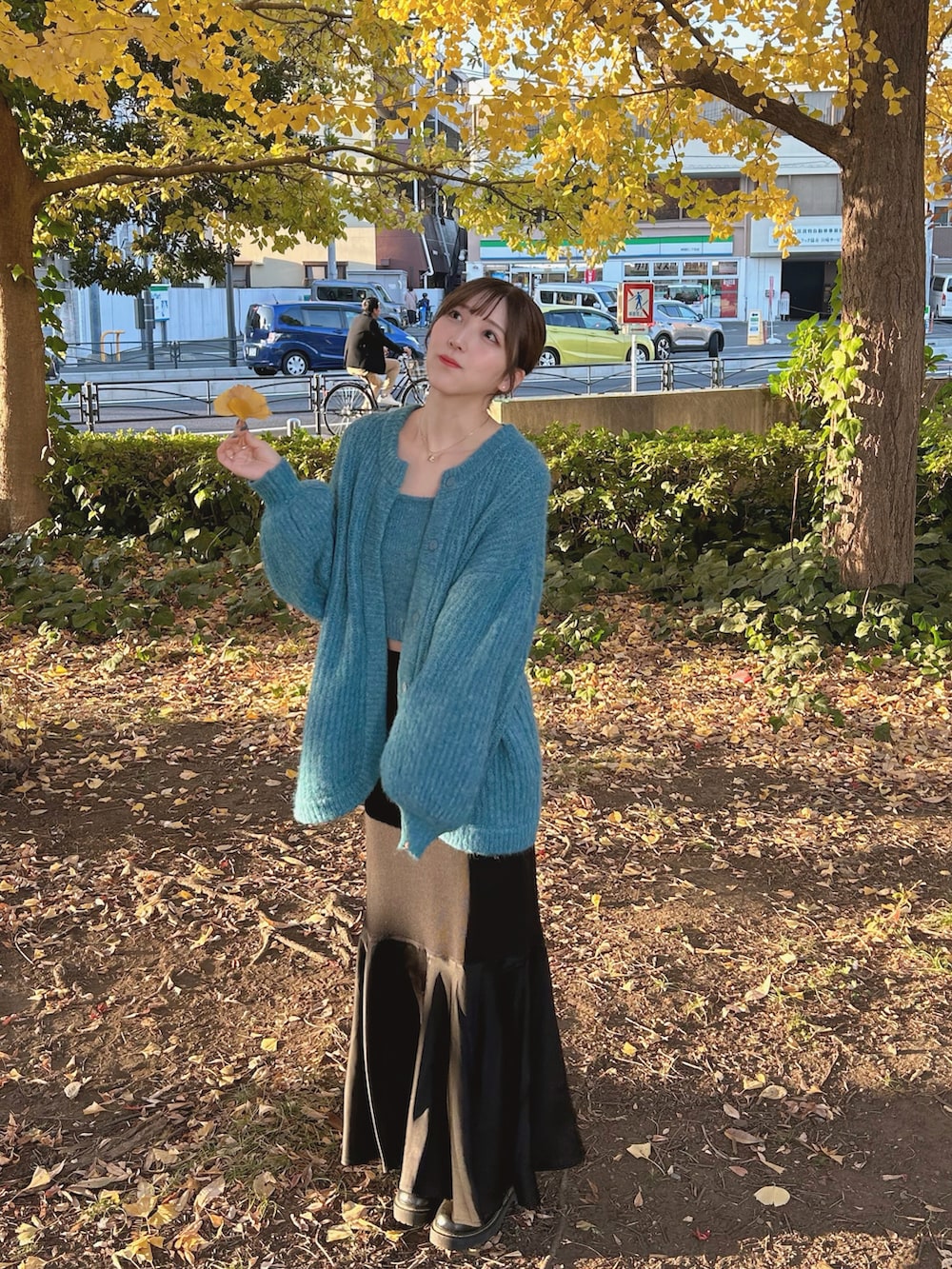 ブルー系のアンサンブル、ブラック系のスカート、ブラック系のブーツを着用したレディースの秋コーディネートの3枚目の写真