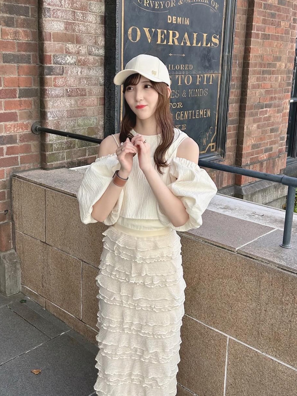 ホワイト系のスニーカー、ホワイト系のトップス、ベージュ系のタンクトップを着用したレディースの夏コーディネートの3枚目の写真