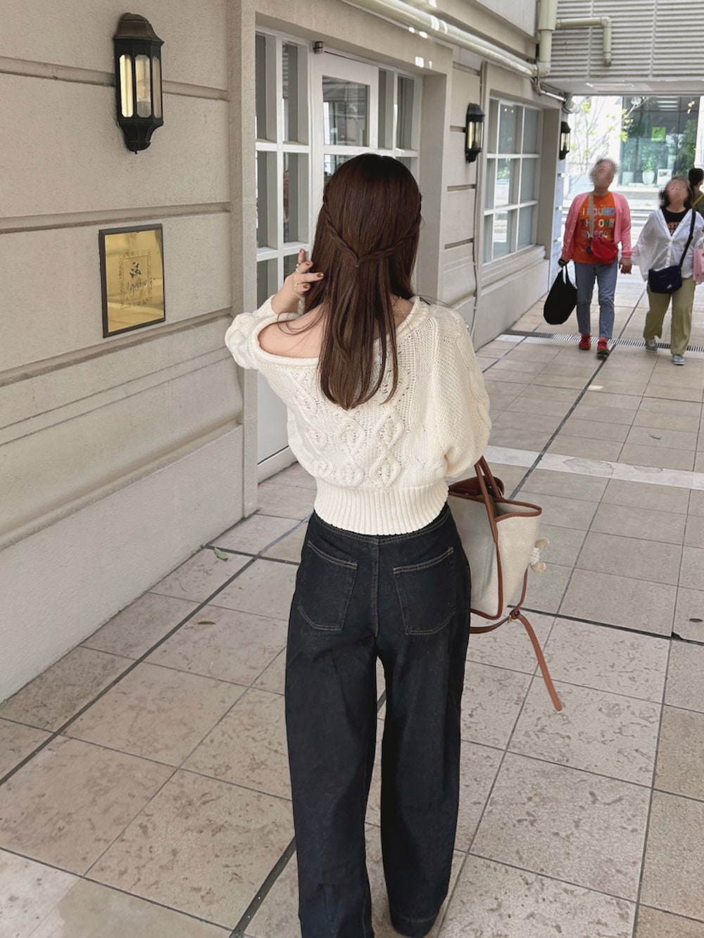 ホワイト系のニット/セーター、ブラック系のデニムパンツ、ホワイト系のブーツを着用したレディースの夏コーディネートの3枚目の写真