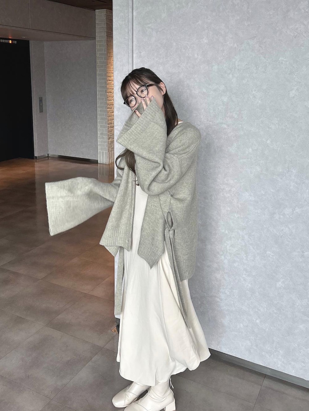 ベージュ系のブーツ、グレー系のカーディガン/ボレロ、ホワイト系のワンピース/ドレスを着用したレディースの秋コーディネートの3枚目の写真