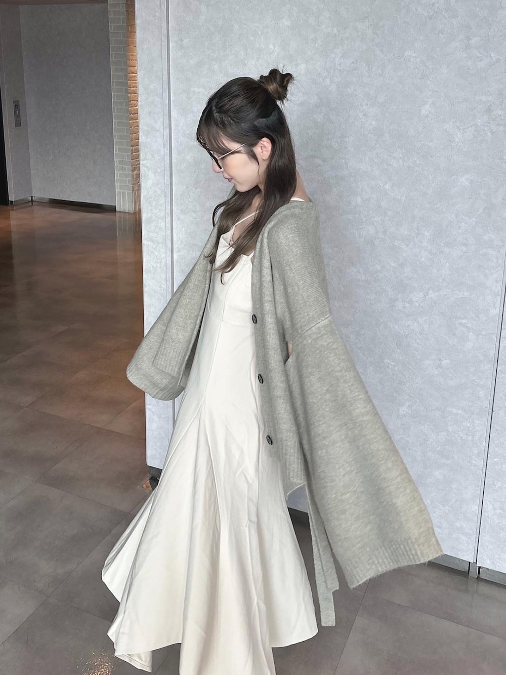 ベージュ系のブーツ、グレー系のカーディガン/ボレロ、ホワイト系のワンピース/ドレスを着用したレディースの秋コーディネートの5枚目の写真