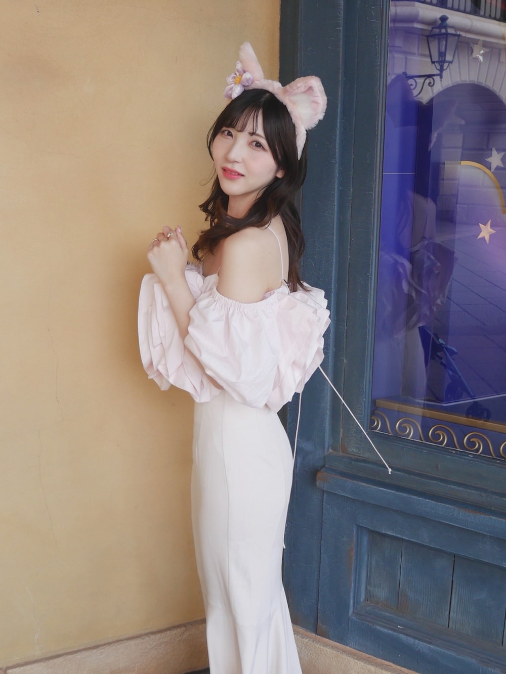 ホワイト系のスカート、ピンク系のトップスを着用したレディースの夏コーディネートの2枚目の写真