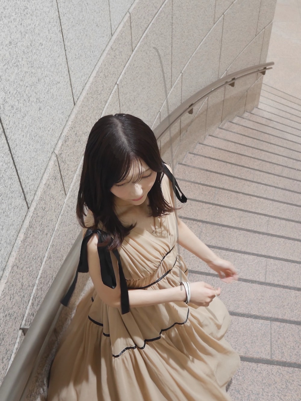 ベージュ系のワンピース、ホワイト系のバングル/リストバンドを着用したレディースの秋コーディネートの2枚目の写真