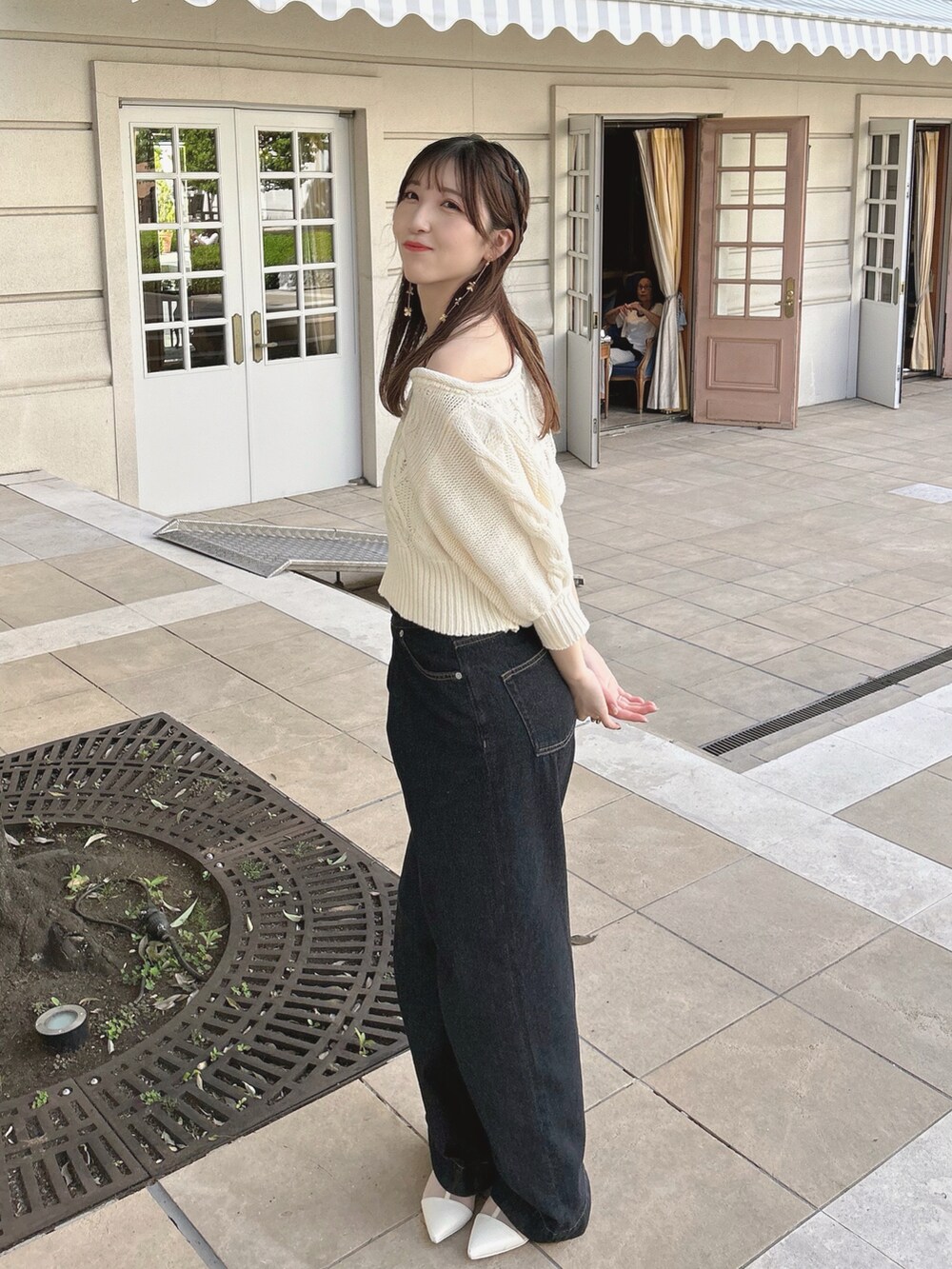 ホワイト系のニット/セーター、ブラック系のデニムパンツ、ホワイト系のブーツを着用したレディースの夏コーディネートの2枚目の写真