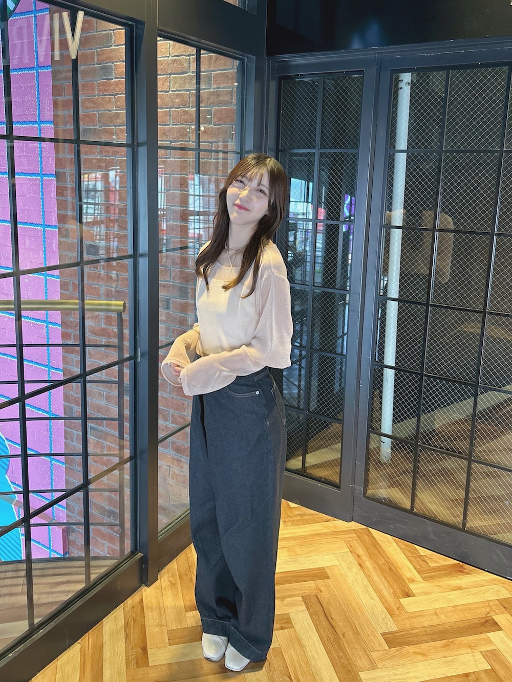 ブラック系のデニムパンツ、ピンク系のその他トップス、ベージュ系のブーツを着用したレディースの夏コーディネートの2枚目の写真