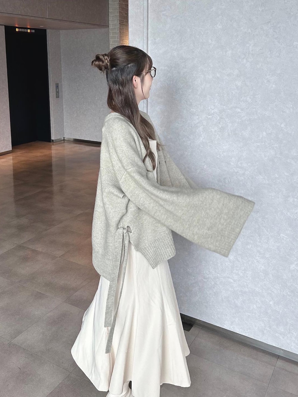 ベージュ系のブーツ、グレー系のカーディガン/ボレロ、ホワイト系のワンピース/ドレスを着用したレディースの秋コーディネートの2枚目の写真