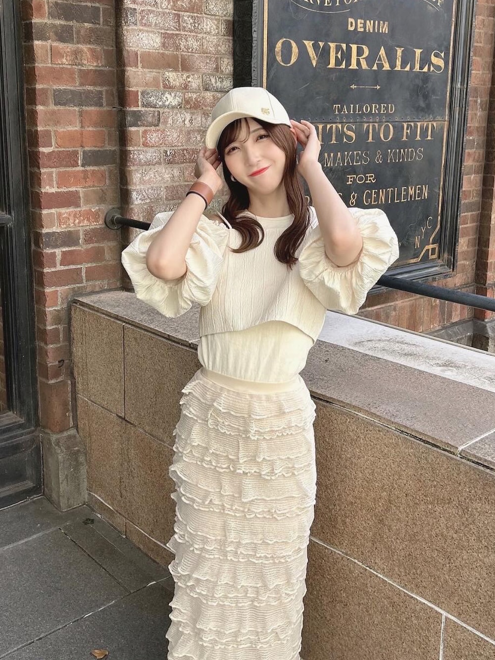 ホワイト系のスニーカー、ホワイト系のトップス、ベージュ系のタンクトップを着用したレディースの夏コーディネートの2枚目の写真