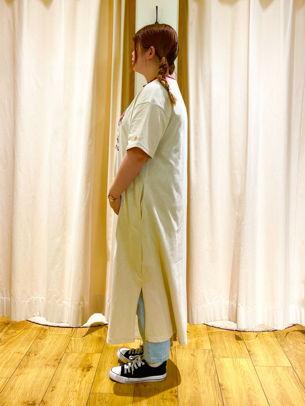 ベージュ系のワンピース、ブルー系のデニムパンツを着用したレディースの春コーディネートの2枚目の写真