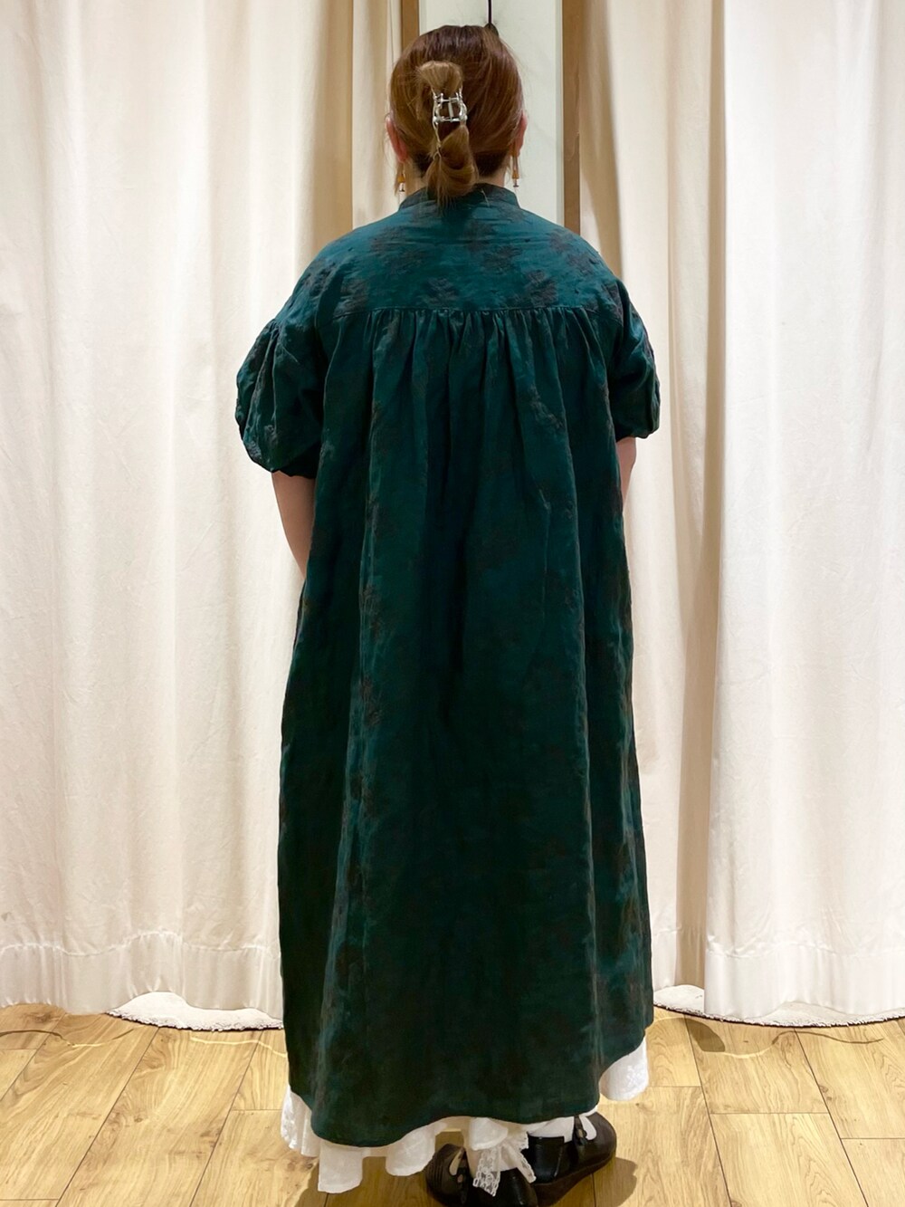 グリーン系のワンピースを着用したレディースの春コーディネートの3枚目の写真