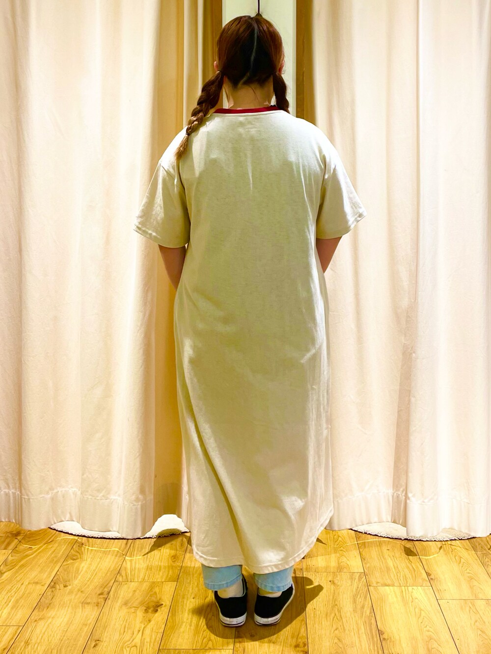 ベージュ系のワンピース、ブルー系のデニムパンツを着用したレディースの春コーディネートの3枚目の写真