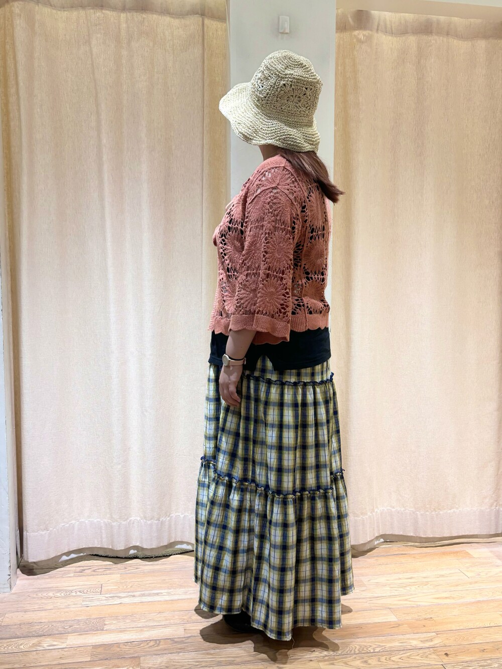 オレンジ系のカーディガン/ボレロ、ブルー系のスカートを着用したレディースの夏コーディネートの2枚目の写真