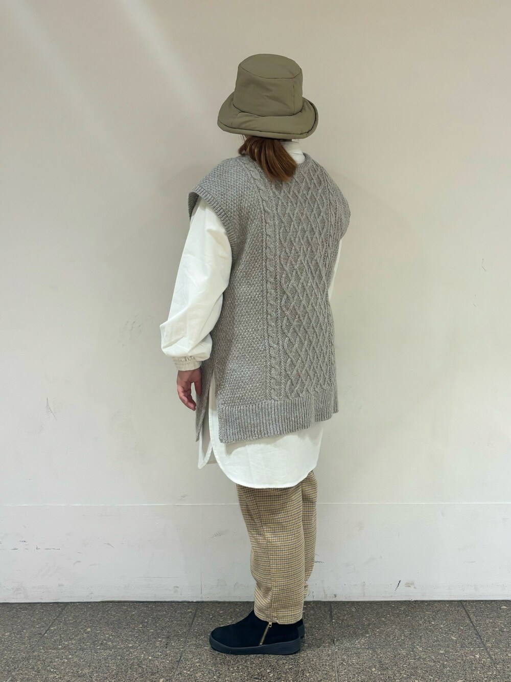 ベージュ系のベストを着用したレディースの冬コーディネートの2枚目の写真