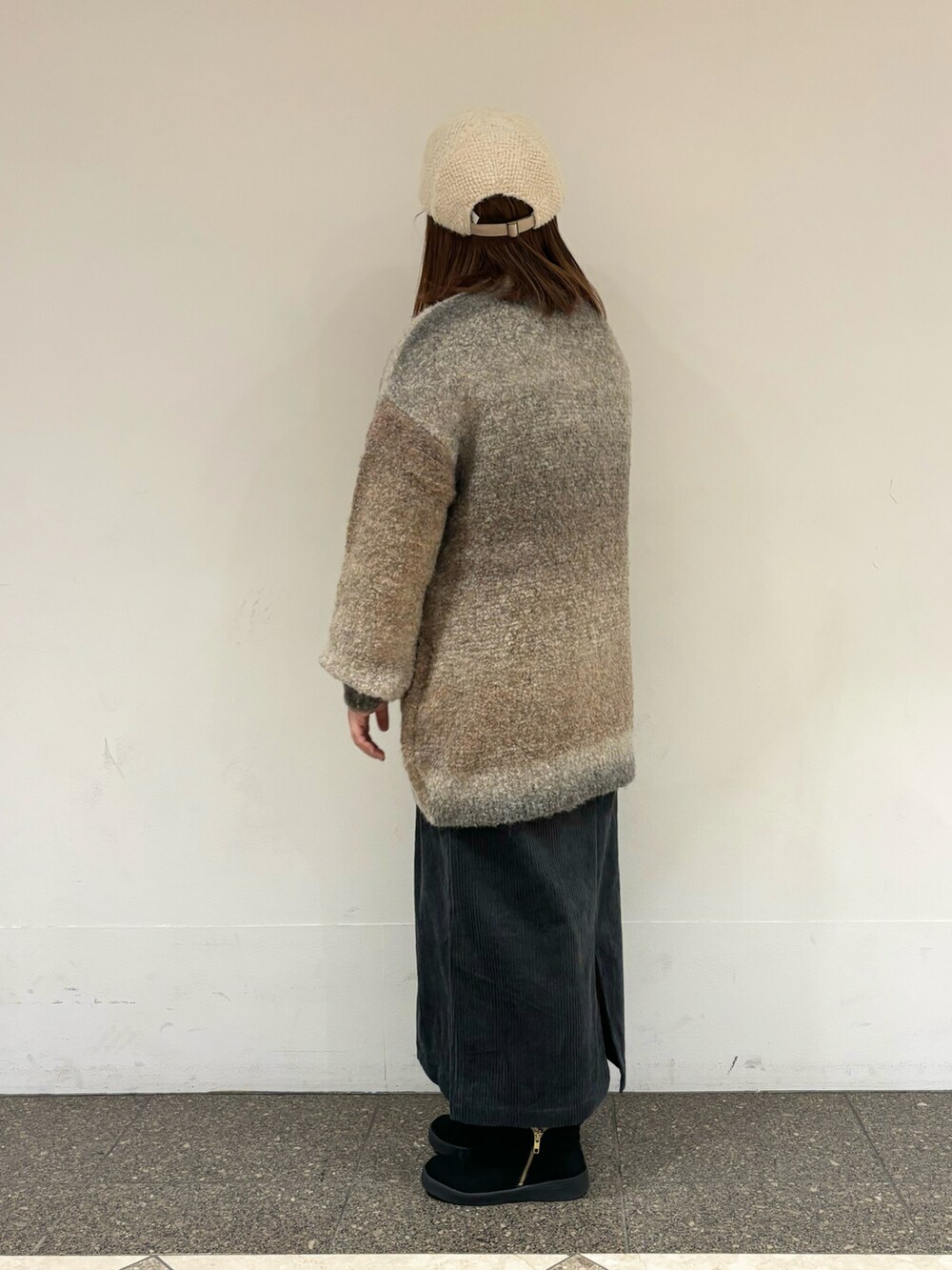 ベージュ系のニット/セーター、ブルー系のスカートを着用したレディースの冬コーディネートの2枚目の写真