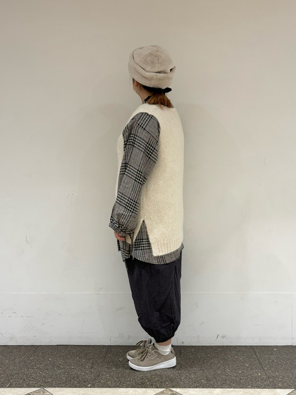 ホワイト系のベスト、ホワイト系のチュニック、ブラック系のその他パンツを着用したレディースの冬コーディネートの2枚目の写真