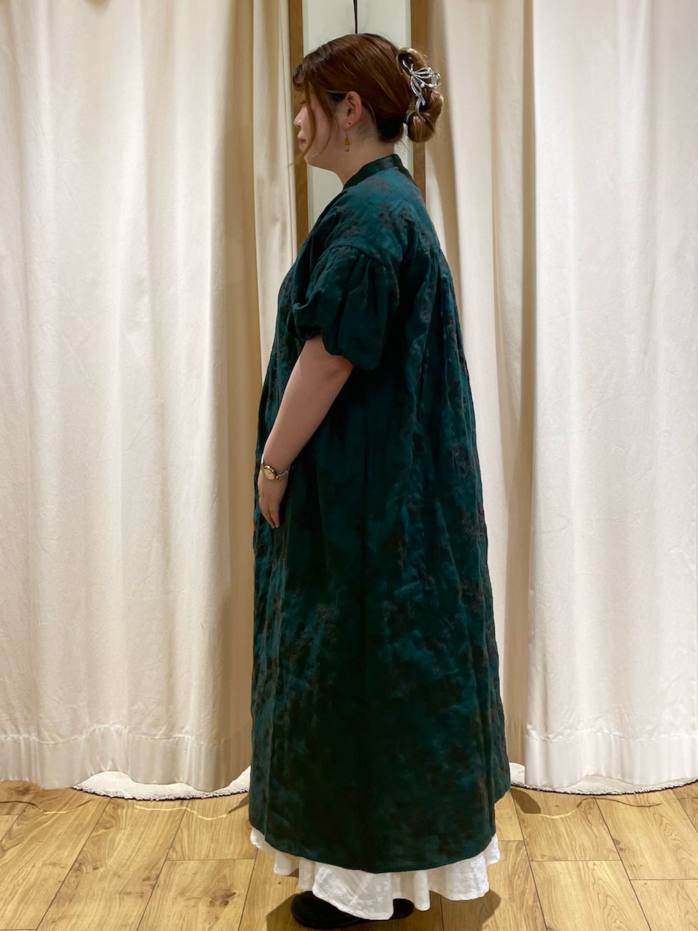 グリーン系のワンピースを着用したレディースの春コーディネートの2枚目の写真