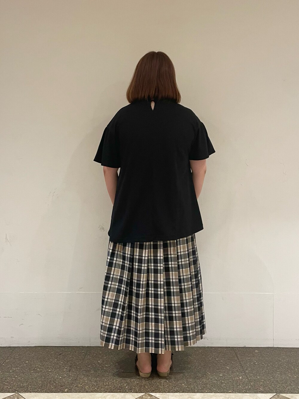 ブラック系のTシャツ/カットソー、ベージュ系のスカートを着用したレディースの夏コーディネートの3枚目の写真