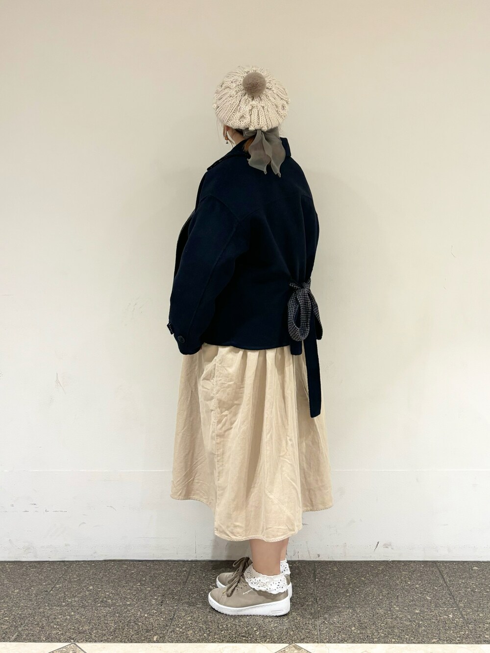 ブルー系のその他アウター、ベージュ系のワンピース、ホワイト系のハットを着用したレディースの冬コーディネートの2枚目の写真