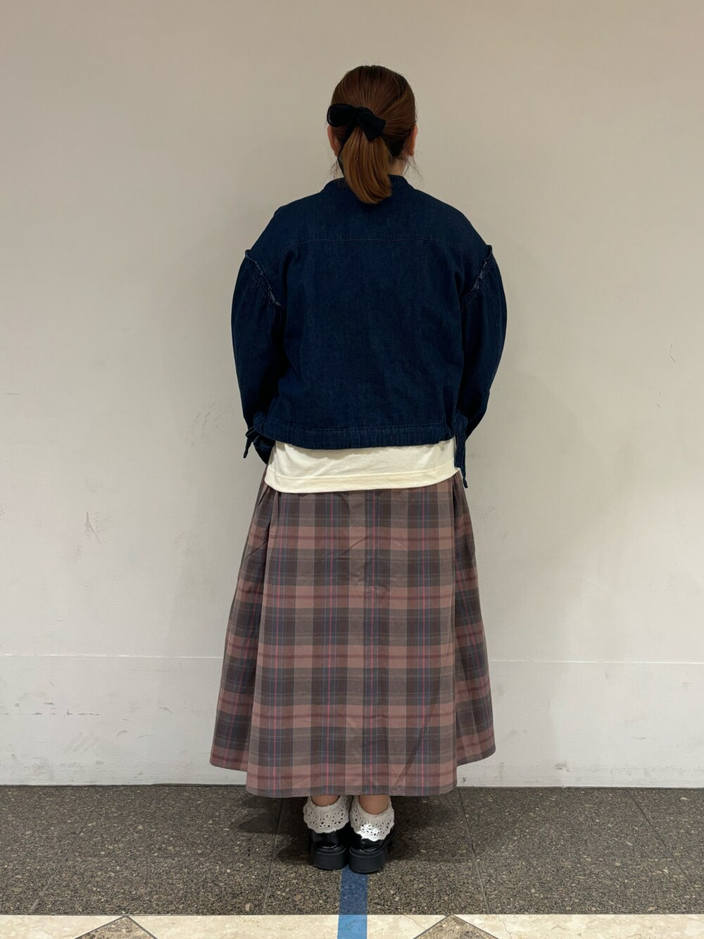 ブルー系のノーカラージャケット、ホワイト系のTシャツ/カットソー、ピンク系のスカートを着用したレディースの秋コーディネートの3枚目の写真