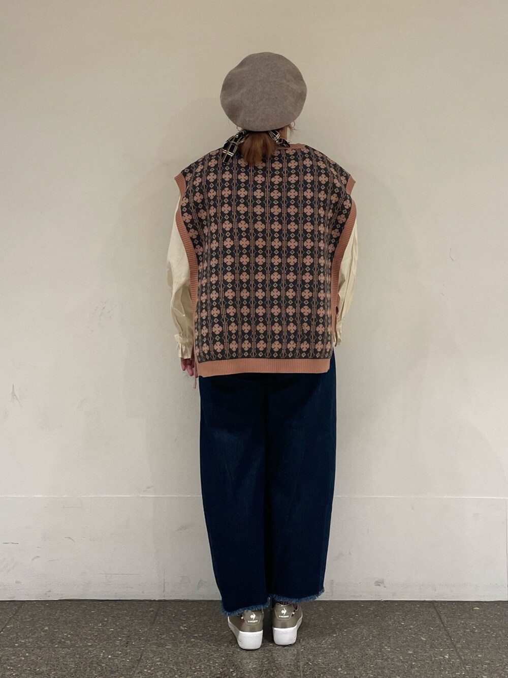 ピンク系のベスト、ホワイト系のTシャツ/カットソー、ブルー系のデニムパンツを着用したレディースの秋コーディネートの3枚目の写真