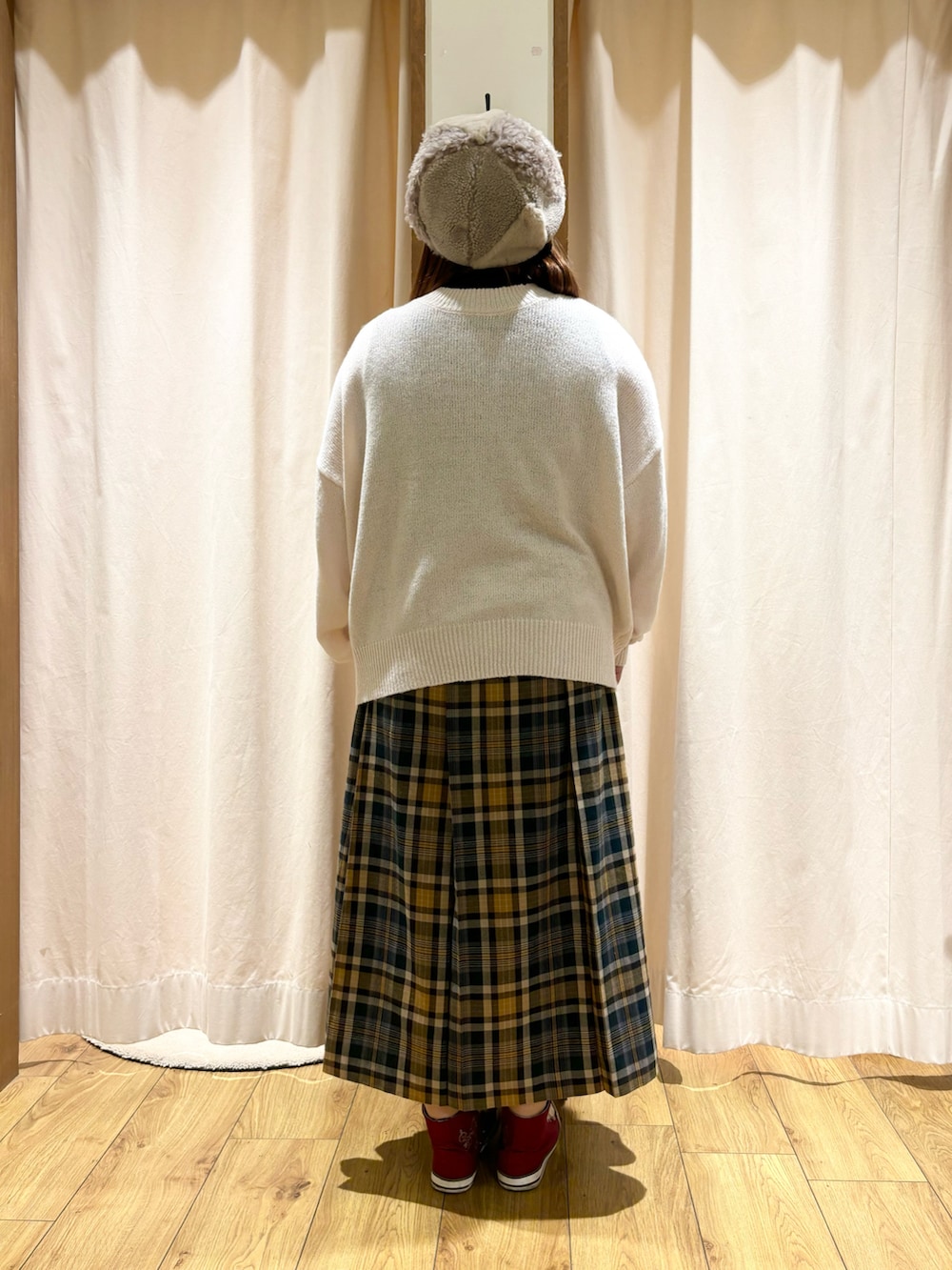 ホワイト系のカーディガン/ボレロ、グリーン系のスカート、ベージュ系のハットを着用したレディースの冬コーディネートの3枚目の写真