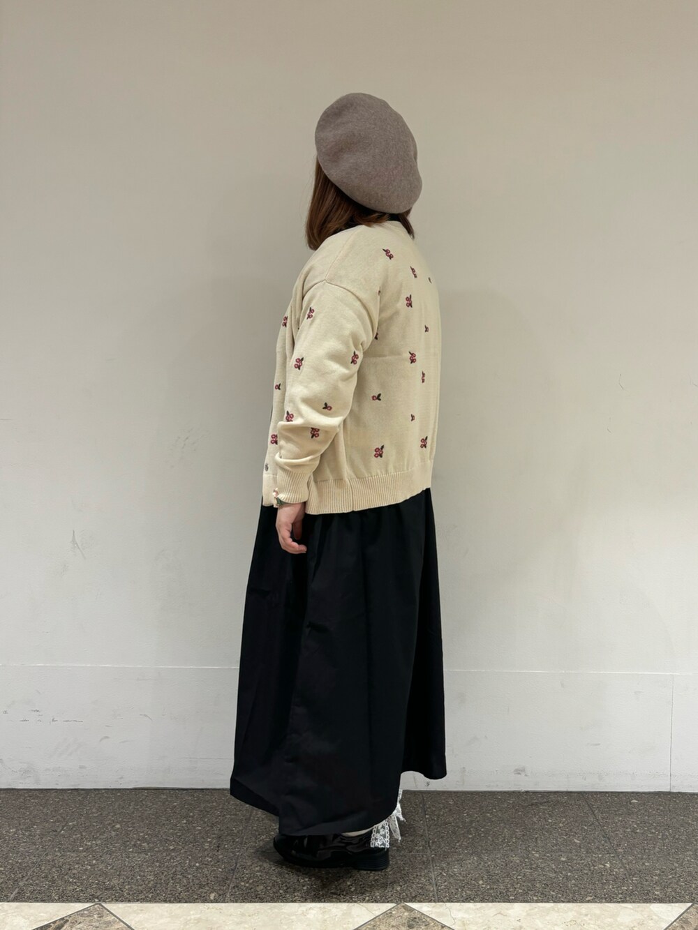 ホワイト系のカーディガン/ボレロ、ブラック系のワンピース、ブラウン系のハットを着用したレディースの秋コーディネートの2枚目の写真