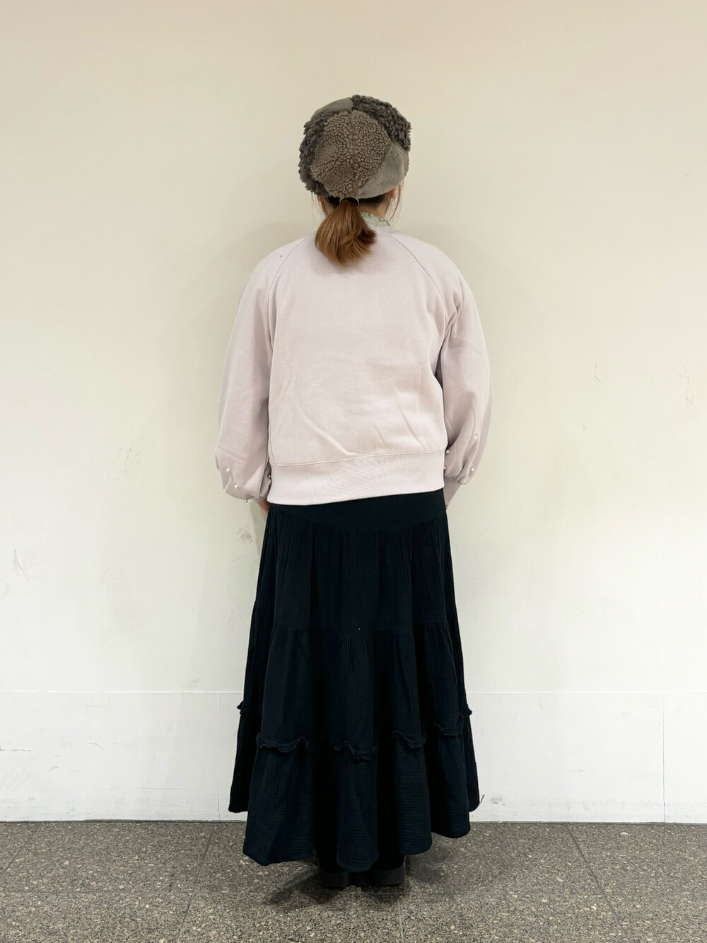 ピンク系のTシャツ/カットソー、ブラック系のスカート、ブラウン系のハットを着用したレディースの冬コーディネートの3枚目の写真