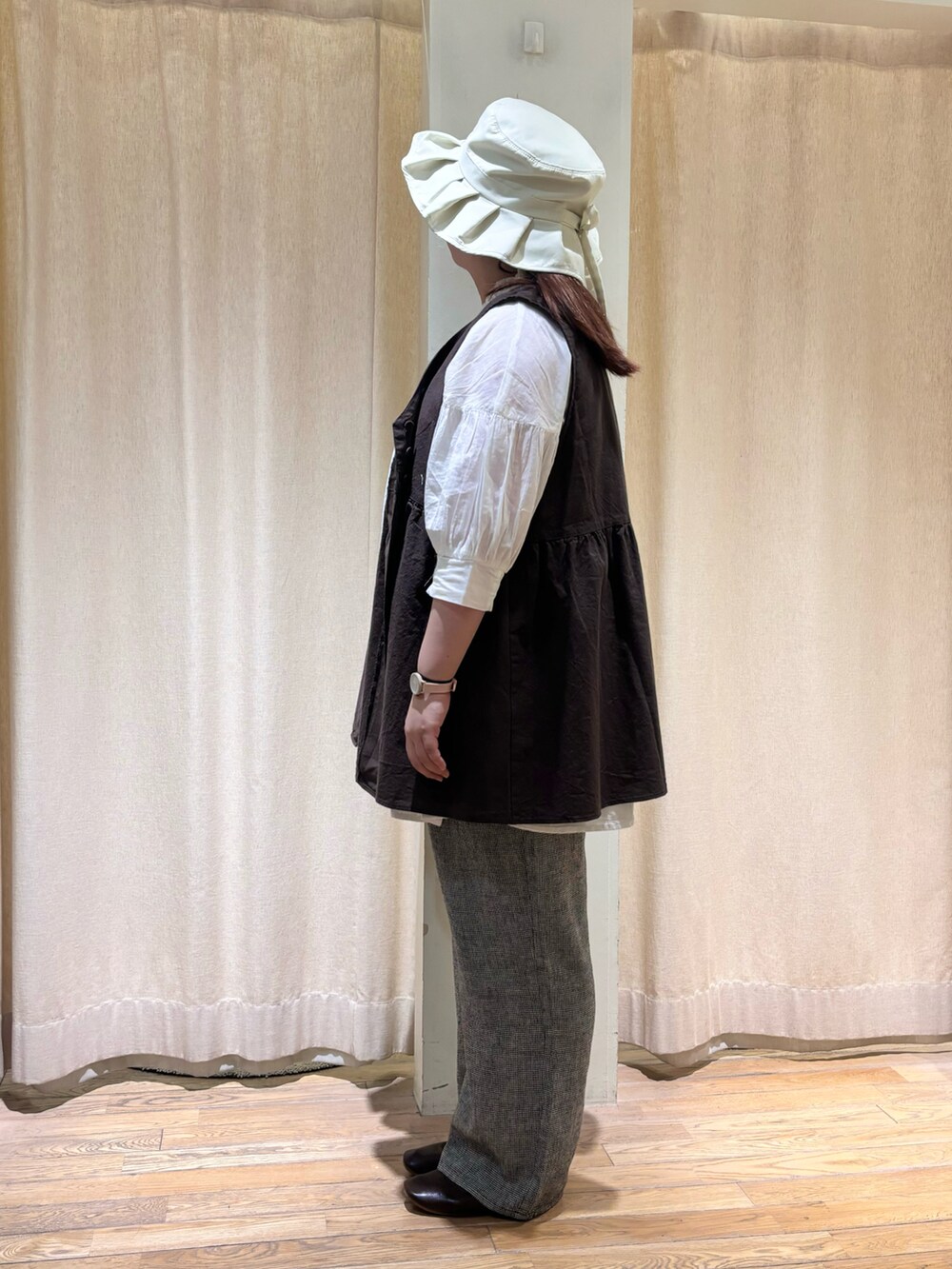 ブラック系のベスト、ホワイト系のシャツ/ブラウス、グレー系のその他パンツを着用したレディースの春コーディネートの2枚目の写真