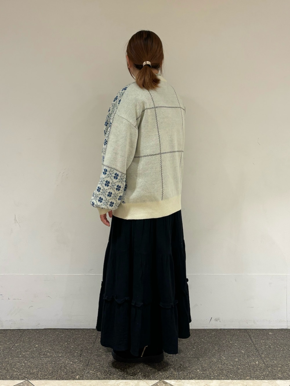 ホワイト系のニット/セーター、ブラック系のスカートを着用したレディースの冬コーディネートの2枚目の写真