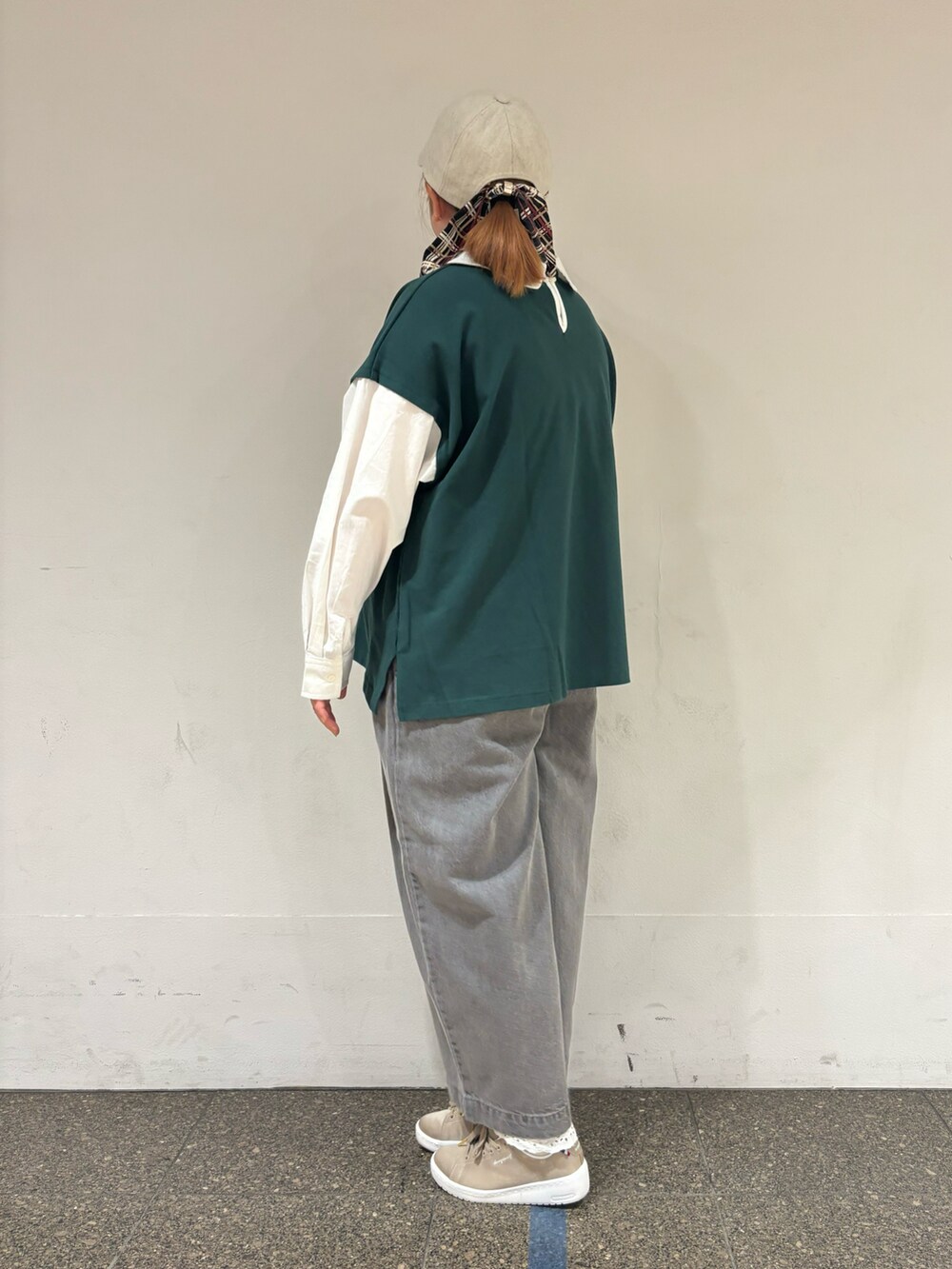 グリーン系のTシャツ/カットソー、グレー系のデニムパンツ、ホワイト系のハットを着用したレディースの秋コーディネートの2枚目の写真