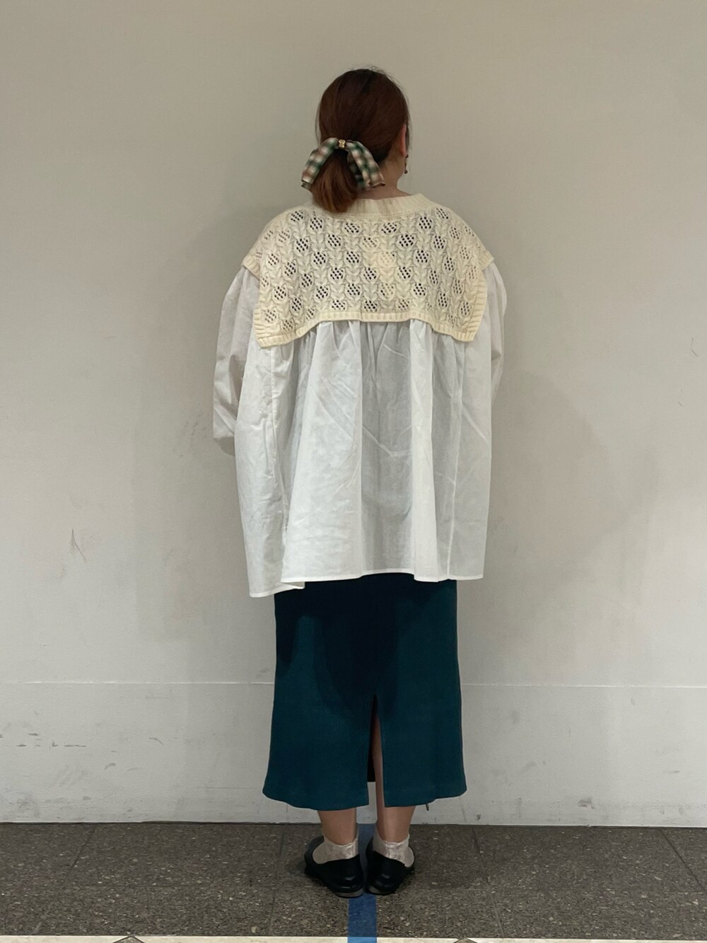 ホワイト系のチュニック、グリーン系のスカートを着用したレディースの秋コーディネートの3枚目の写真