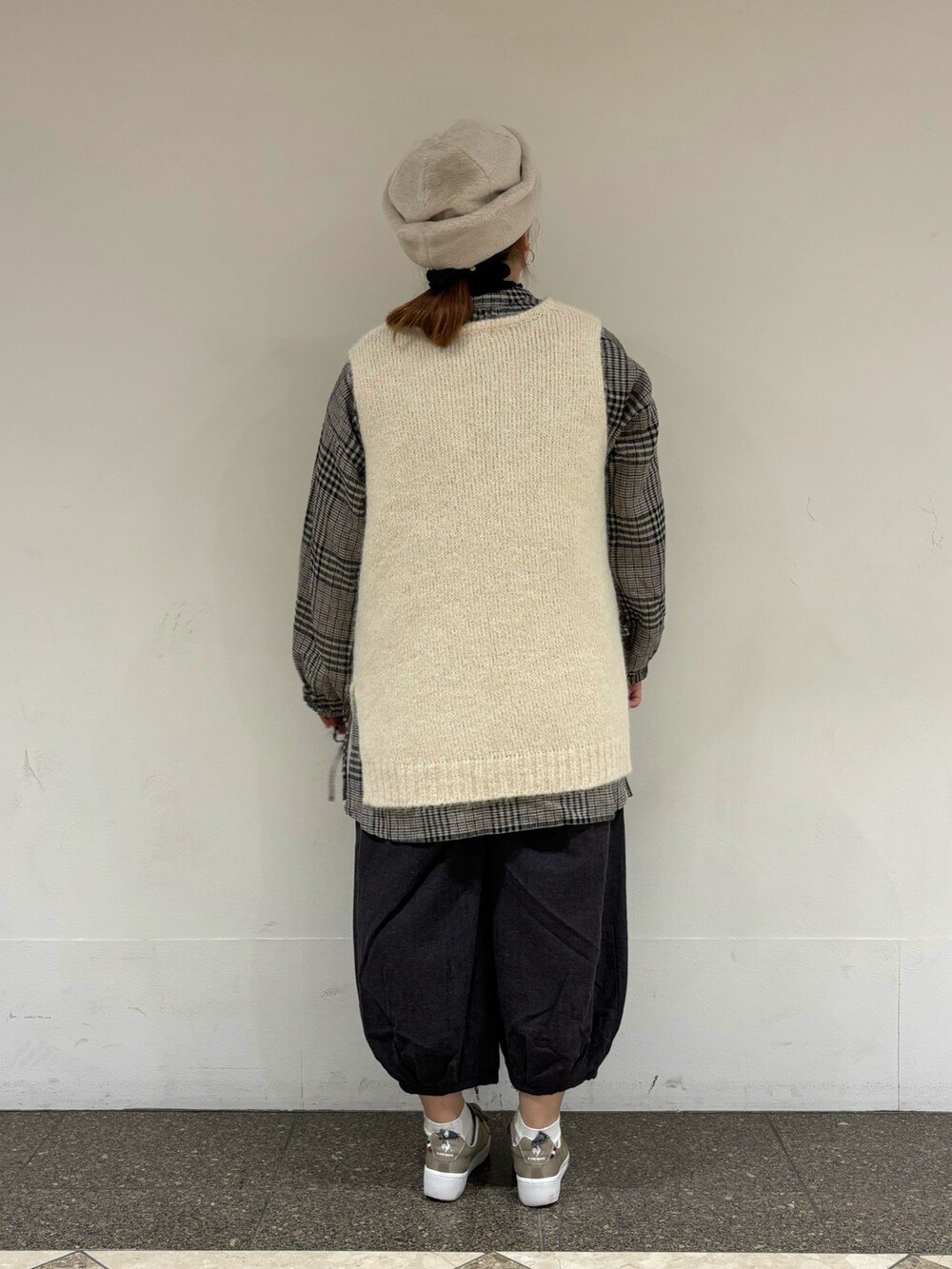 ホワイト系のベスト、ホワイト系のチュニック、ブラック系のその他パンツを着用したレディースの冬コーディネートの3枚目の写真