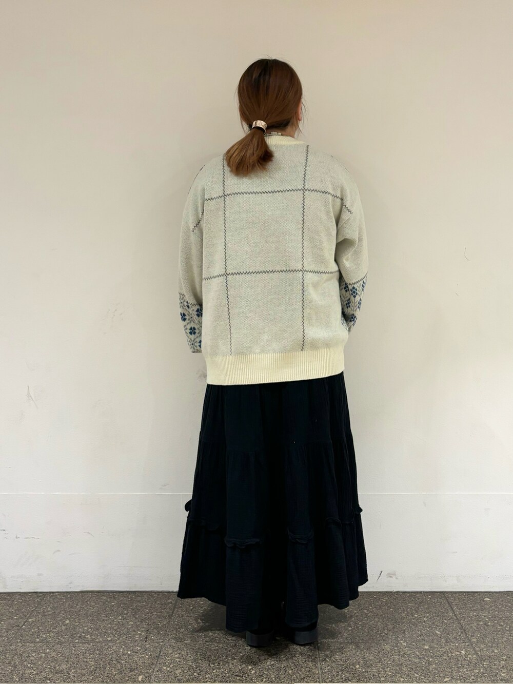 ホワイト系のニット/セーター、ブラック系のスカートを着用したレディースの冬コーディネートの3枚目の写真