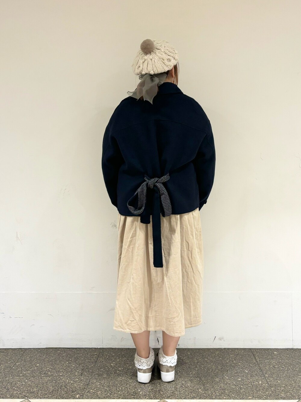 ブルー系のその他アウター、ベージュ系のワンピース、ホワイト系のハットを着用したレディースの冬コーディネートの3枚目の写真