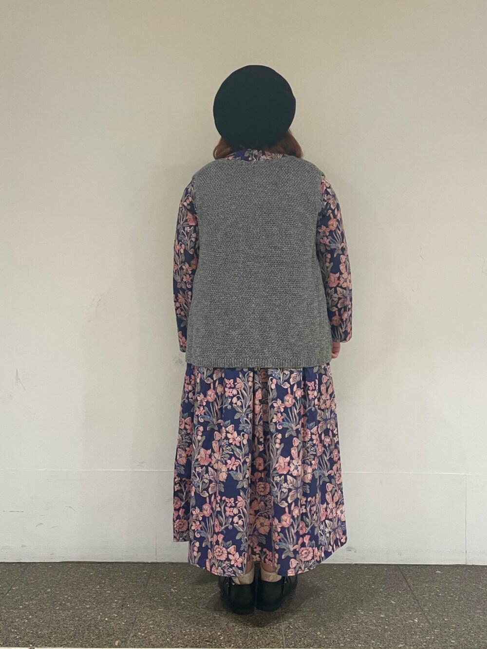 ブルー系のワンピース、グレー系のベスト、ブラック系のハットを着用したレディースの秋コーディネートの3枚目の写真