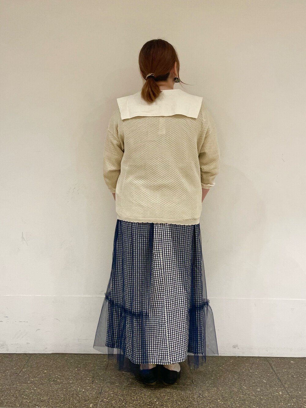 ホワイト系のシャツ/ブラウス、ホワイト系のカーディガン/ボレロ、ブルー系のスカートを着用したレディースの秋コーディネートの3枚目の写真